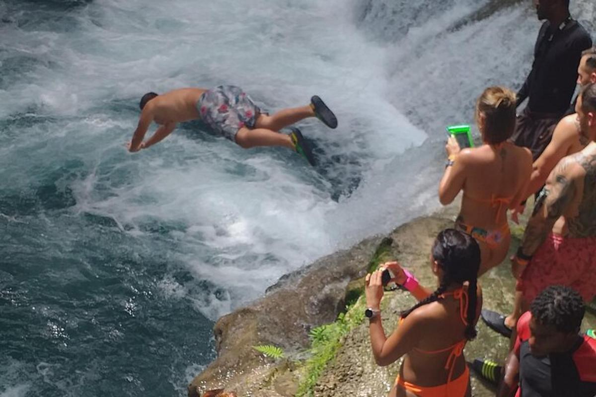 людина, яка стрибає з водоспаду в річку