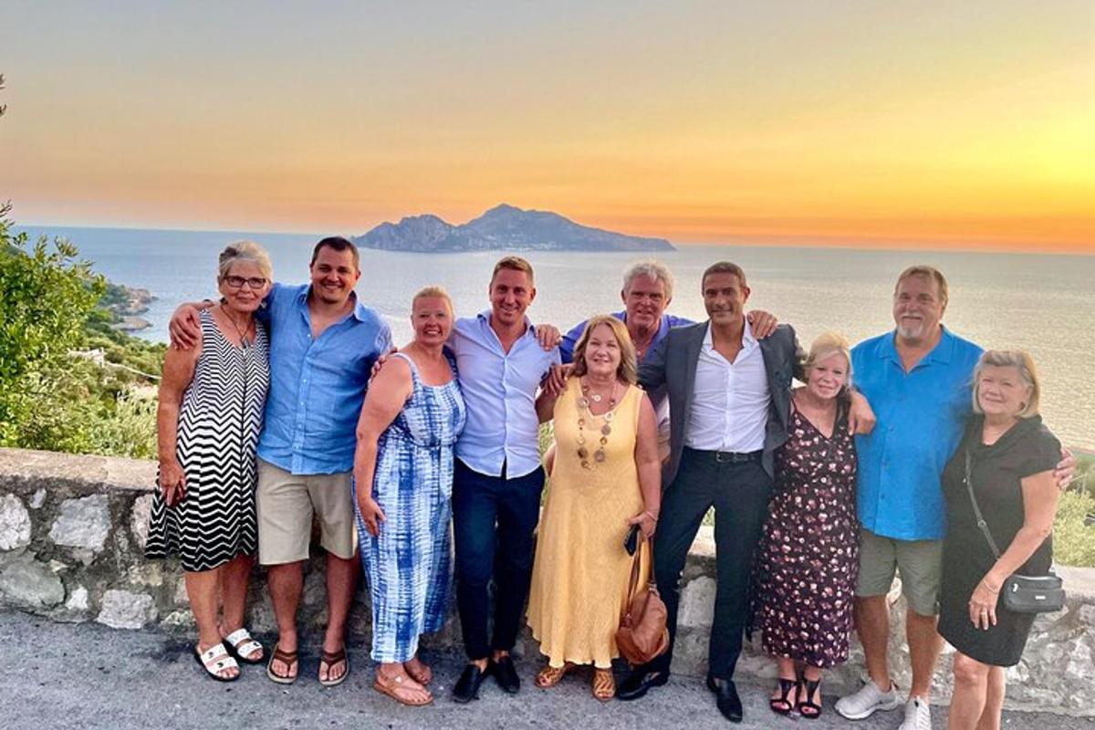 skupina lidí pózujících pro fotografii u oceánu