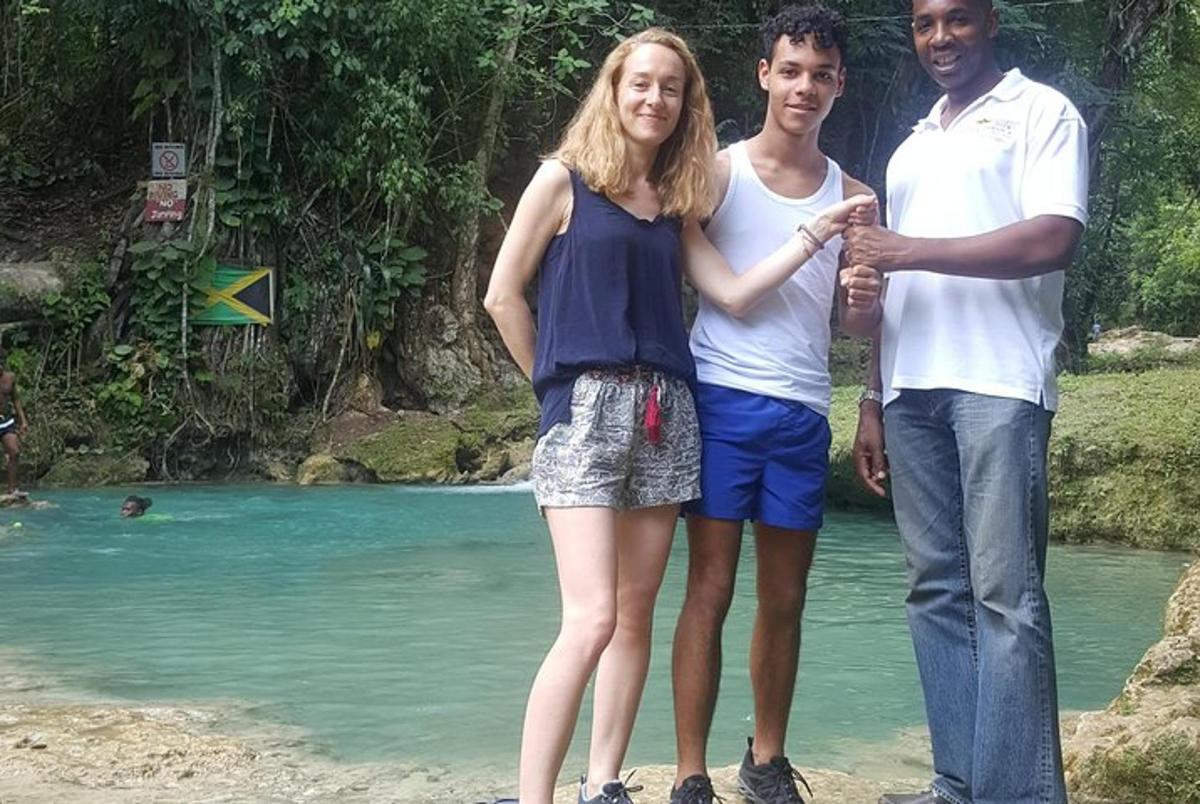 una donna e due uomini in piedi su una spiaggia vicino all'acqua