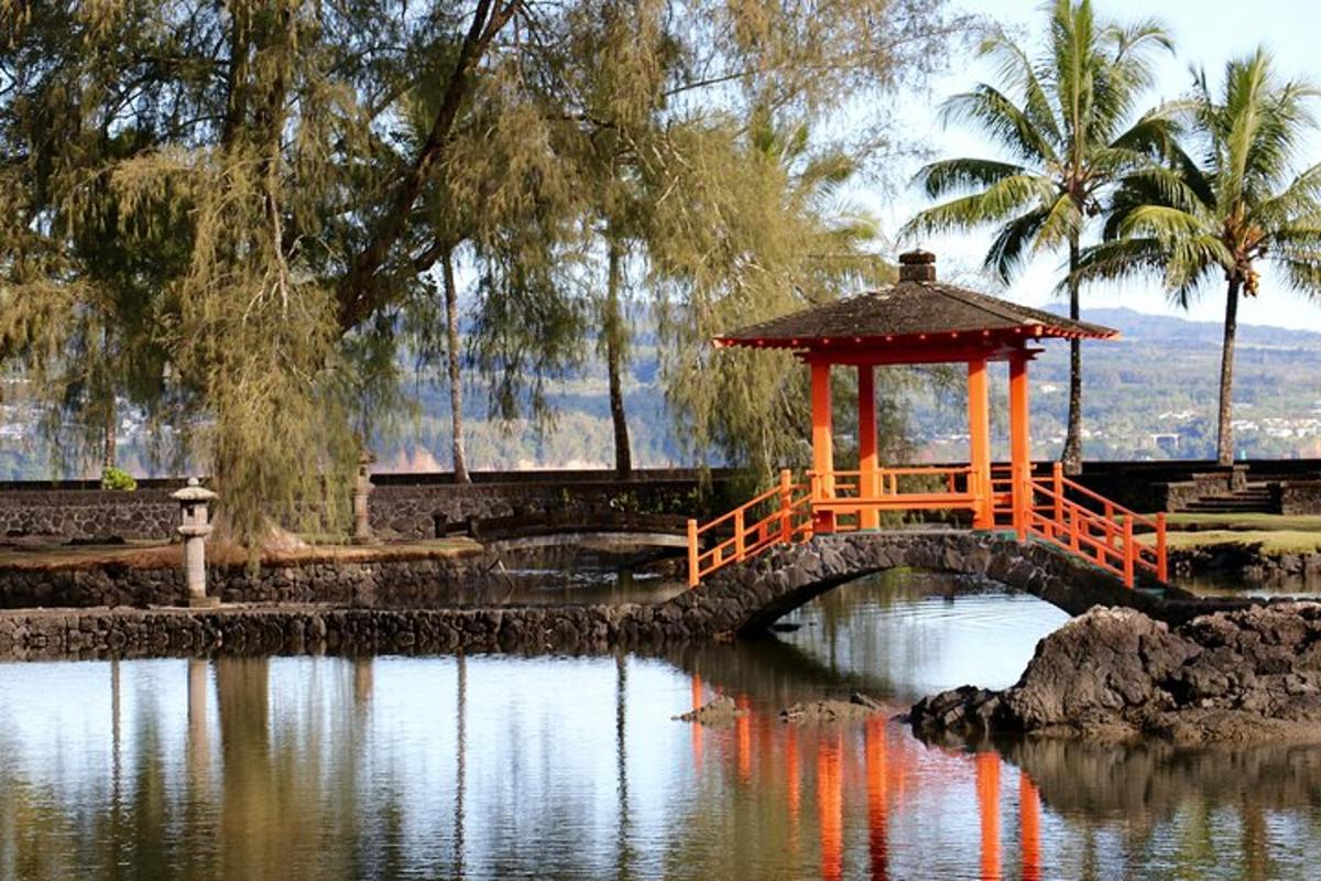 an orange bridge over a pond with a gazebo