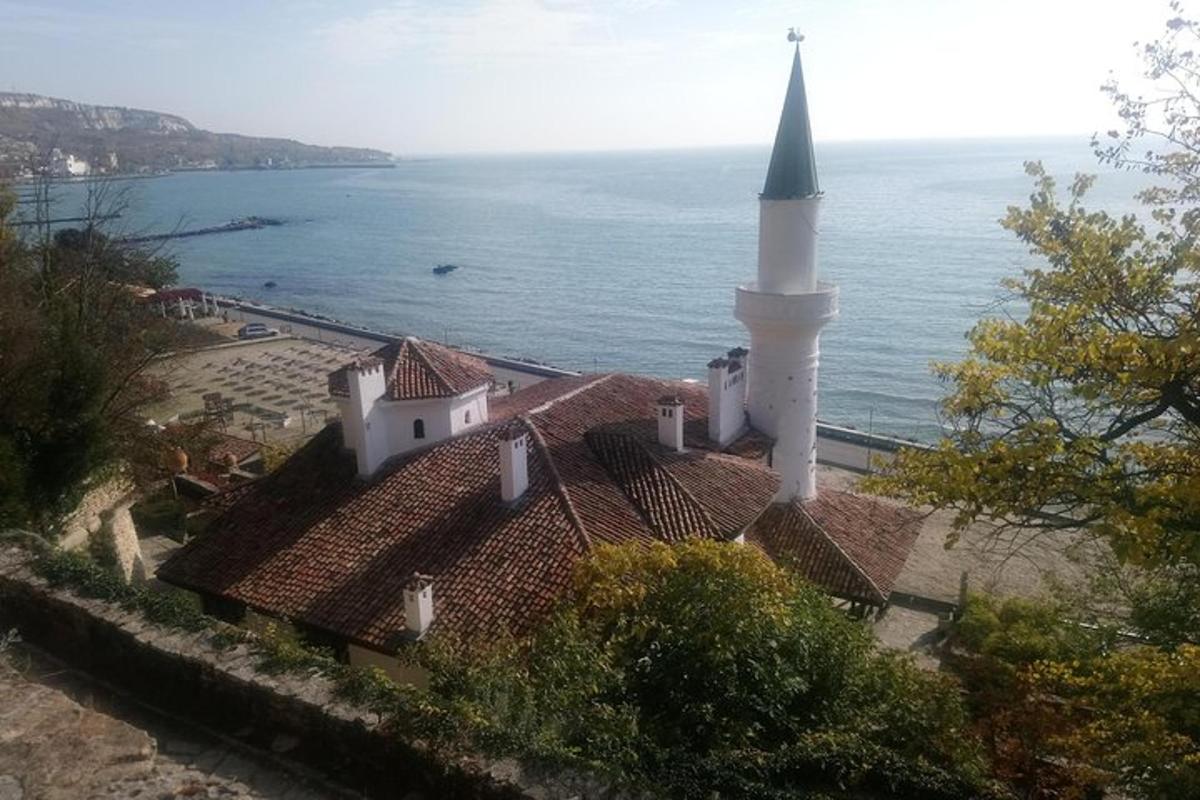 una chiesa con un campanile in cima a un edificio vicino all'oceano