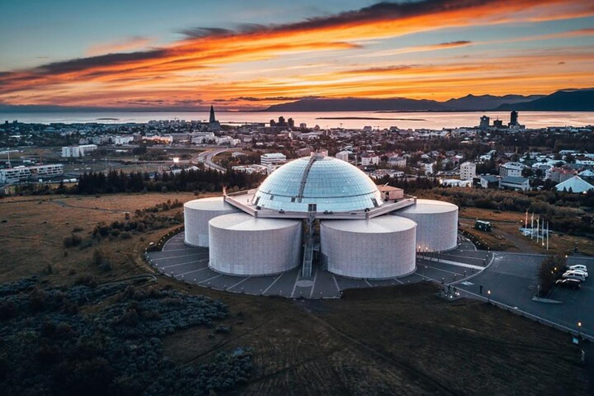 un grande edificio bianco con una città sullo sfondo