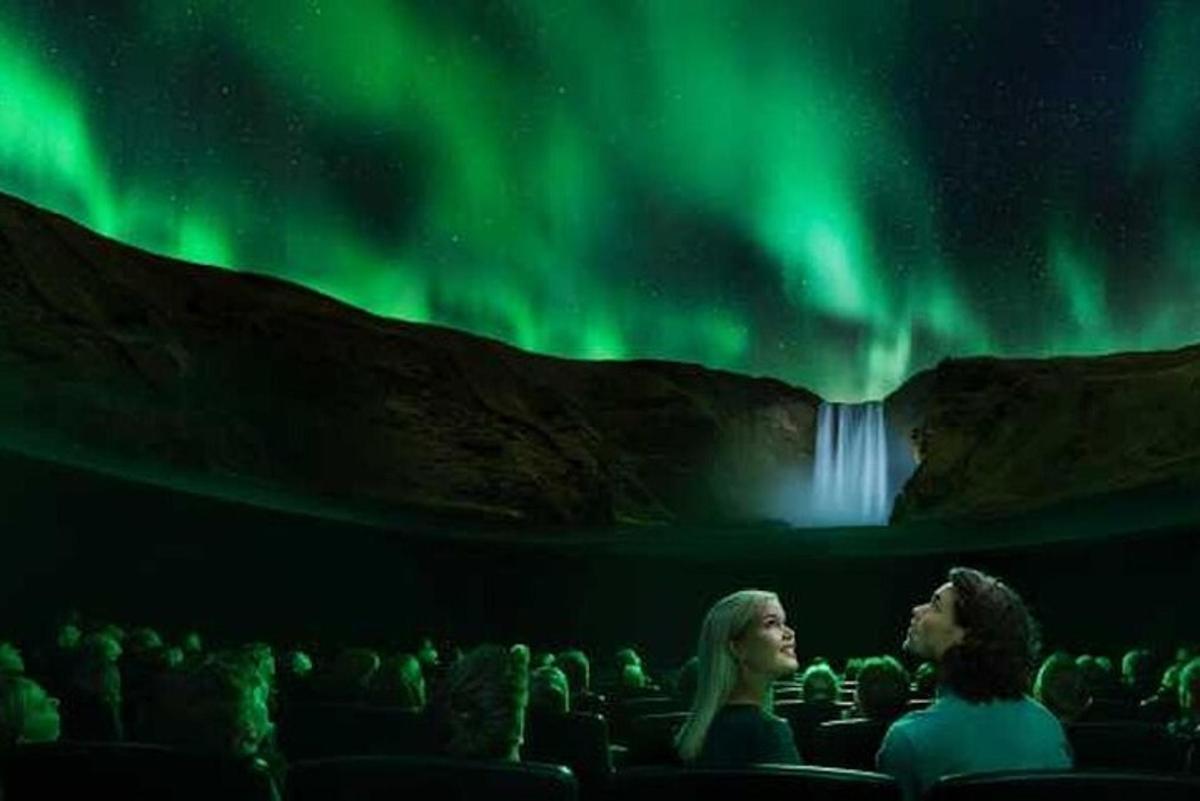 un gruppo di persone sedute tra il pubblico a guardare l'aurora boreale