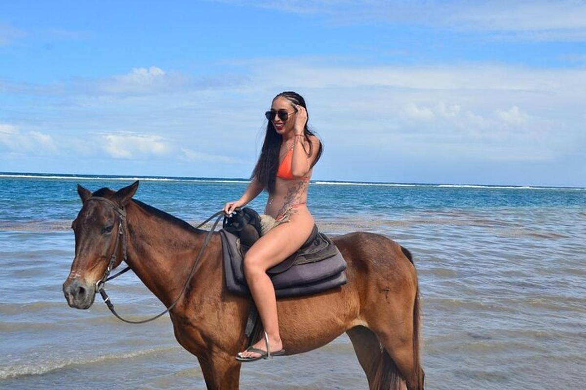 una donna in bikini a cavallo sulla spiaggia