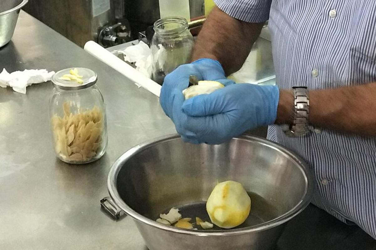 um homem de luvas azuis segurando uma tigela de comida