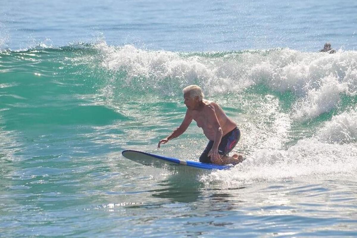 un home cavalcant una onada sobre una taula de surf a l'oceà