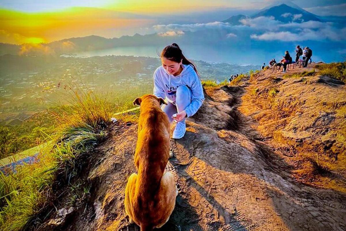 Una mujer dándole una botella de agua a un perro.