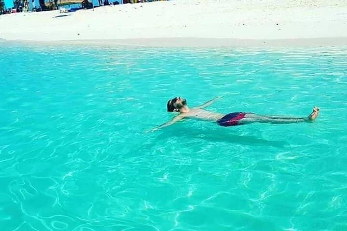 một cô gái trẻ đang nằm trong nước trên bãi biển