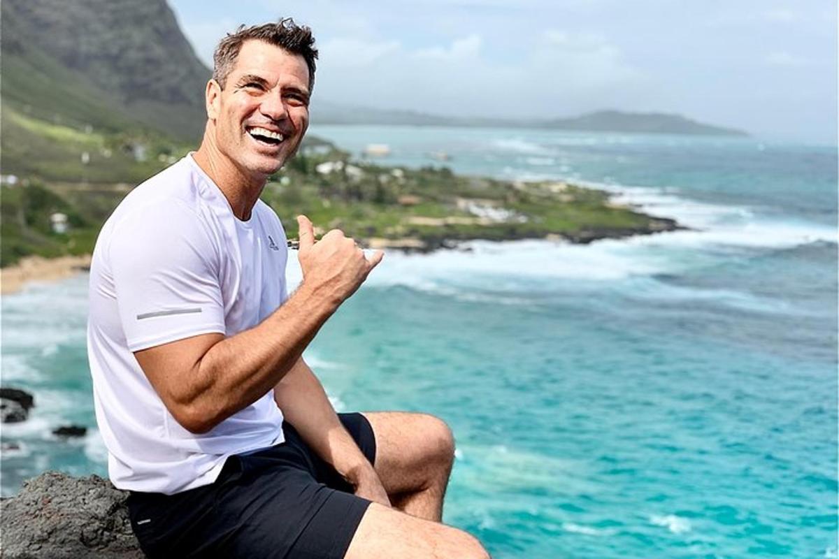 um homem sentado em uma rocha perto do oceano