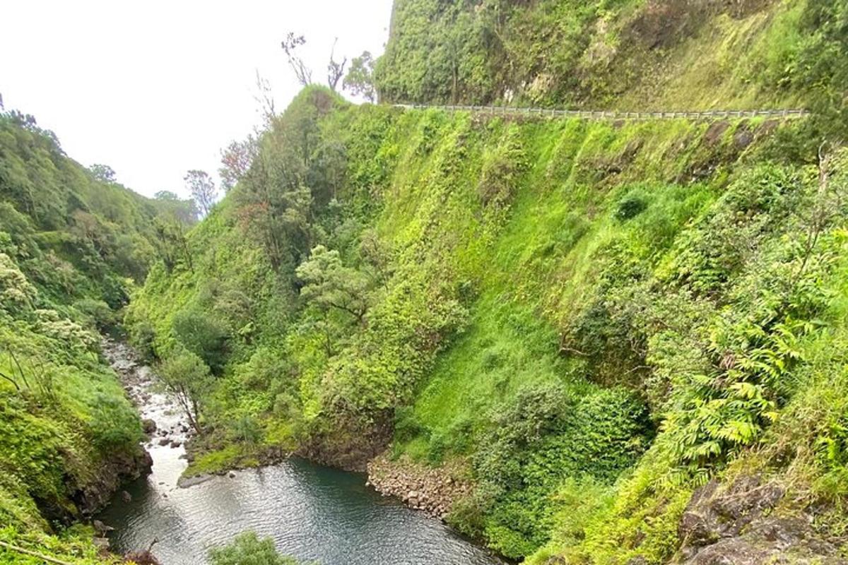 una montagna con un fiume e un ponte su di essa