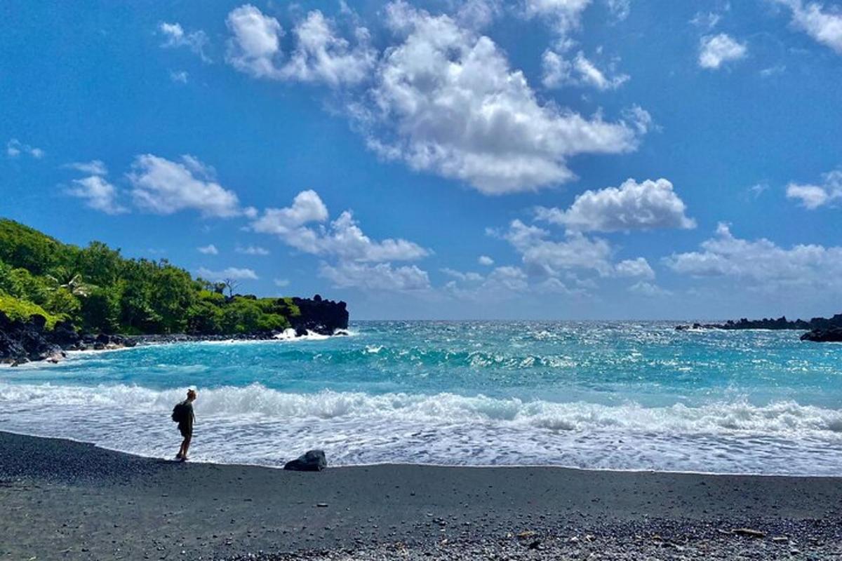 un uomo in piedi su una spiaggia vicino all'oceano