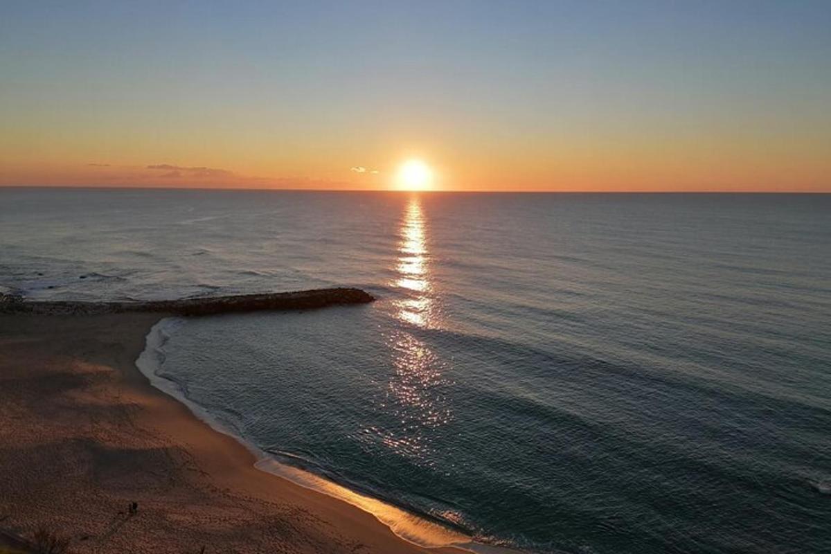 un tramonto sull'oceano con una spiaggia