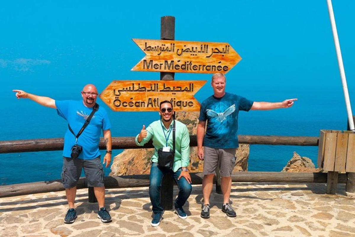 Un grupo de tres hombres de pie bajo una señal de calle.