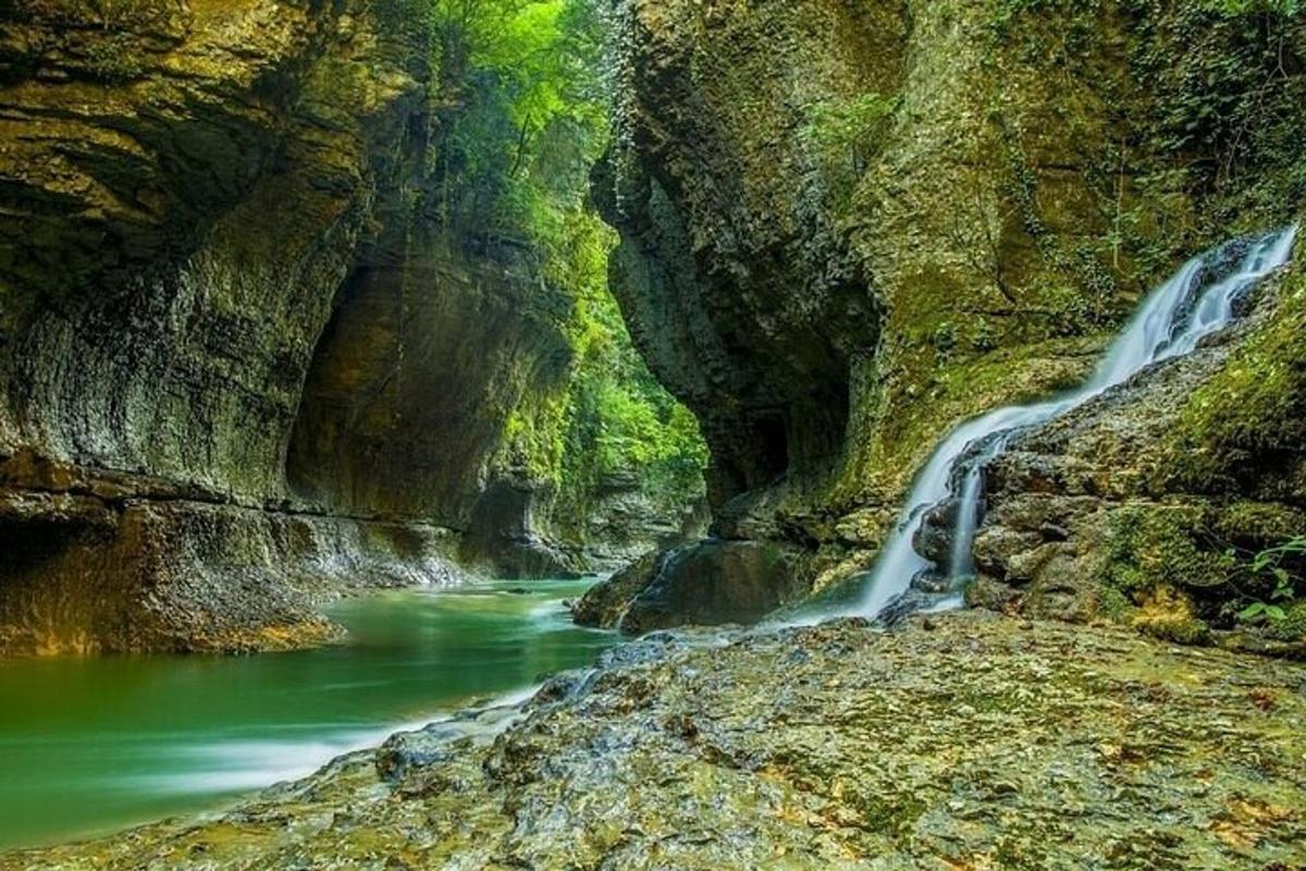 a river in a canyon with a waterfall