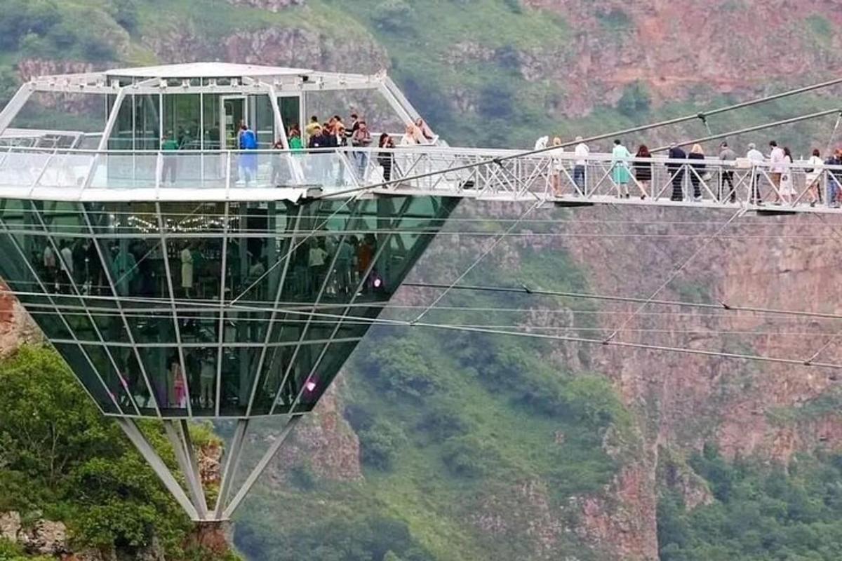 un gruppo di persone su un ponte sospeso sopra una montagna