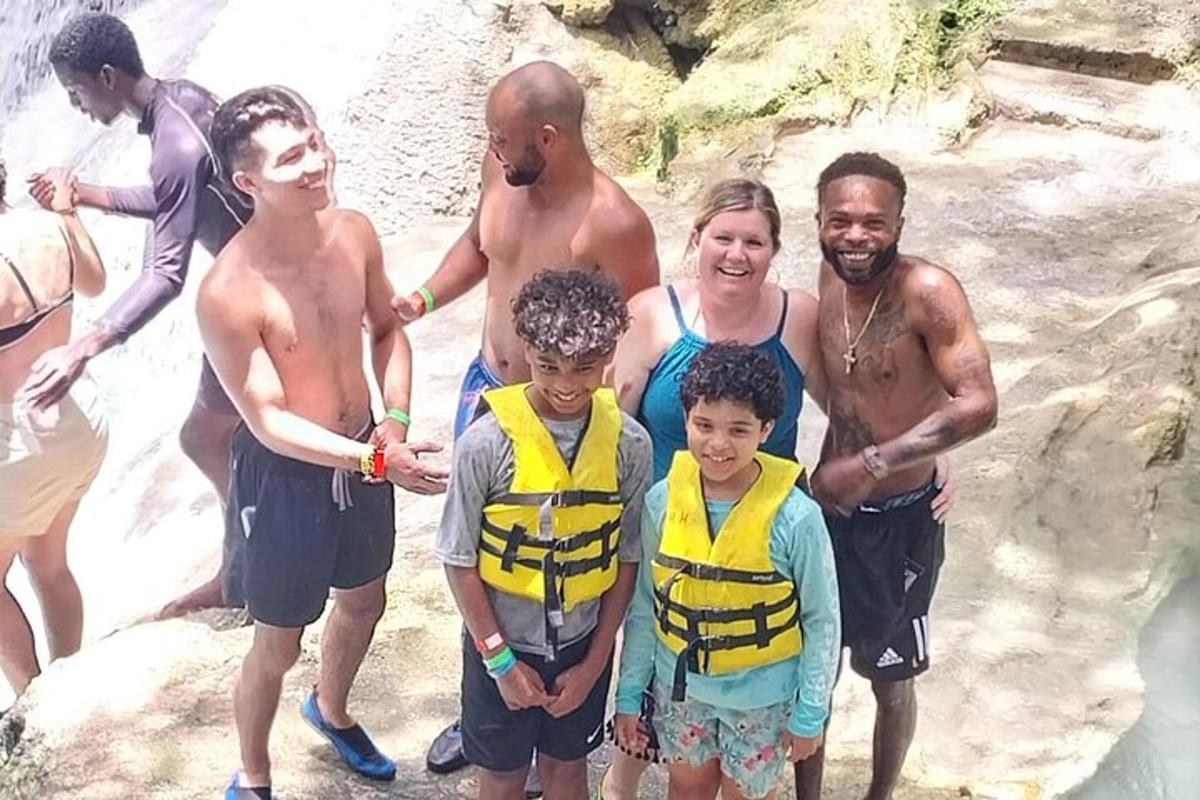 un gruppo di persone in posa per una foto su una cascata