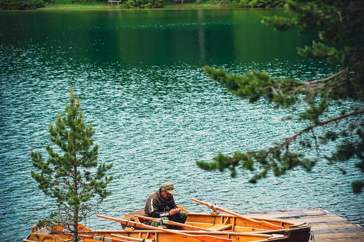 un hombre sentado en un bote en un lago