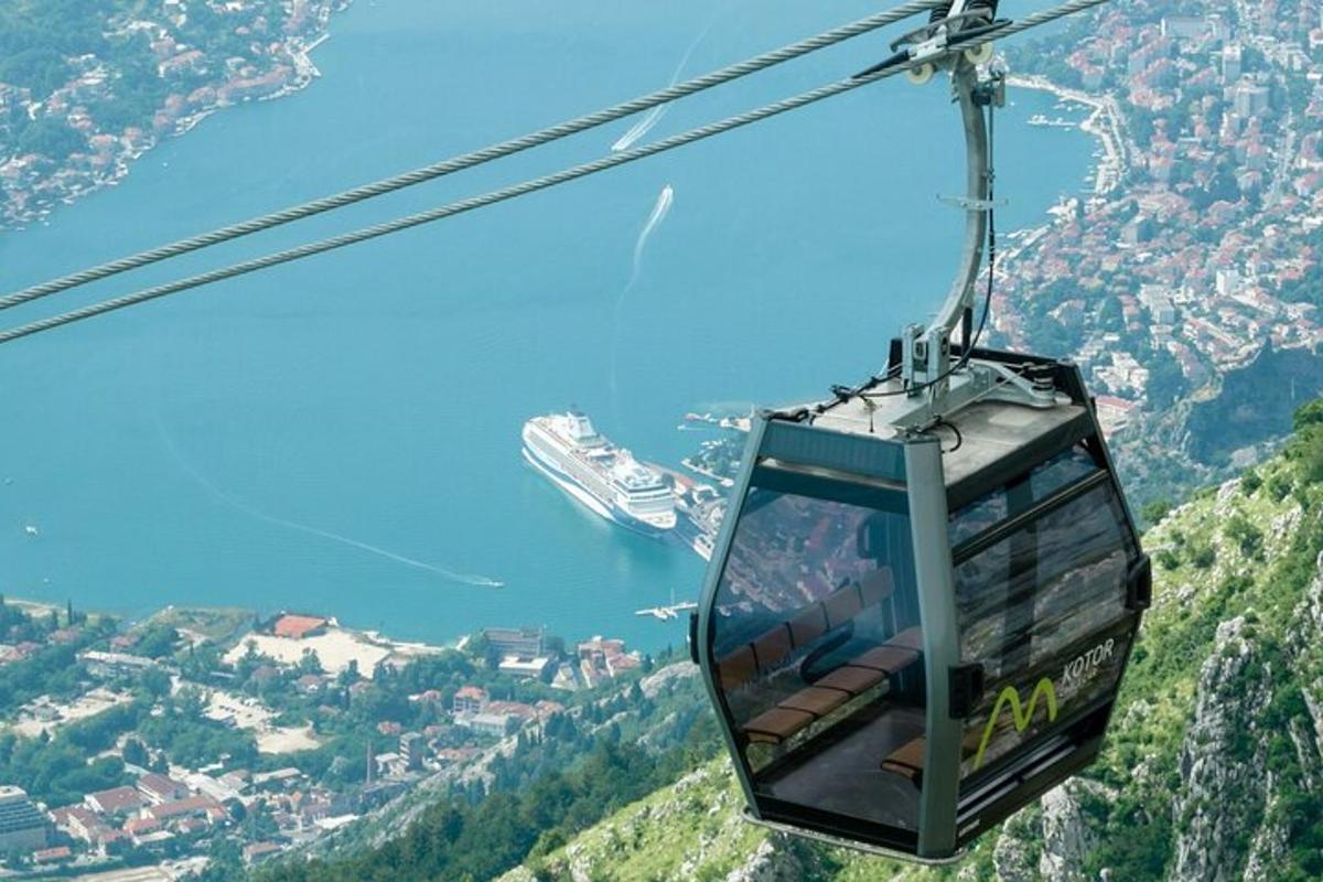 gondola letící nad horou s výletní lodí
