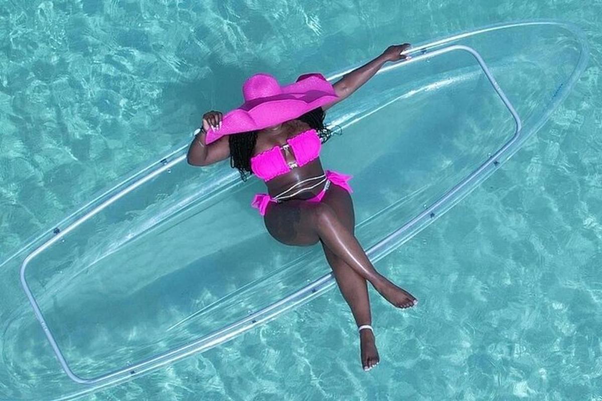 o femeie într-o rochie roz și o pălărie întinsă pe o piscină