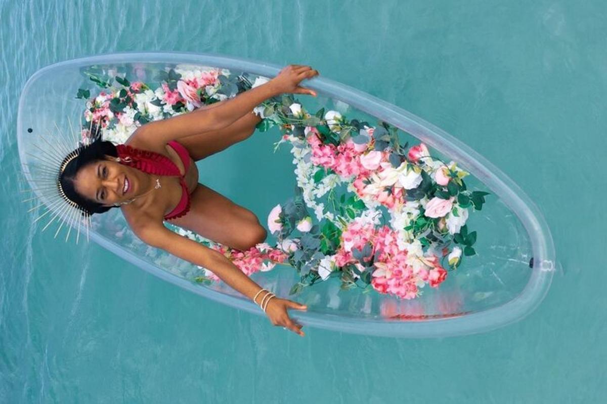 isang babaeng lumulutang sa isang mangkok ng mga bulaklak sa tubig