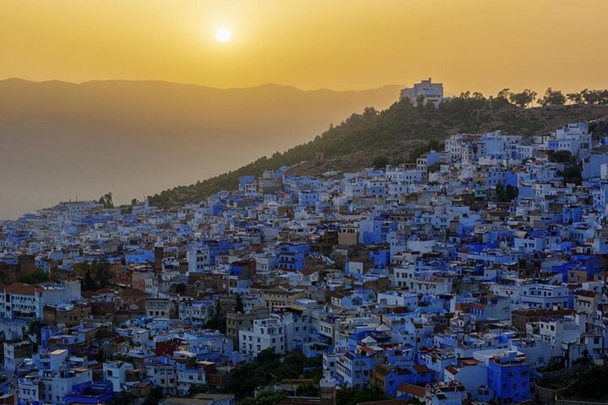 a view of the blue city of chefchaouen at sunset