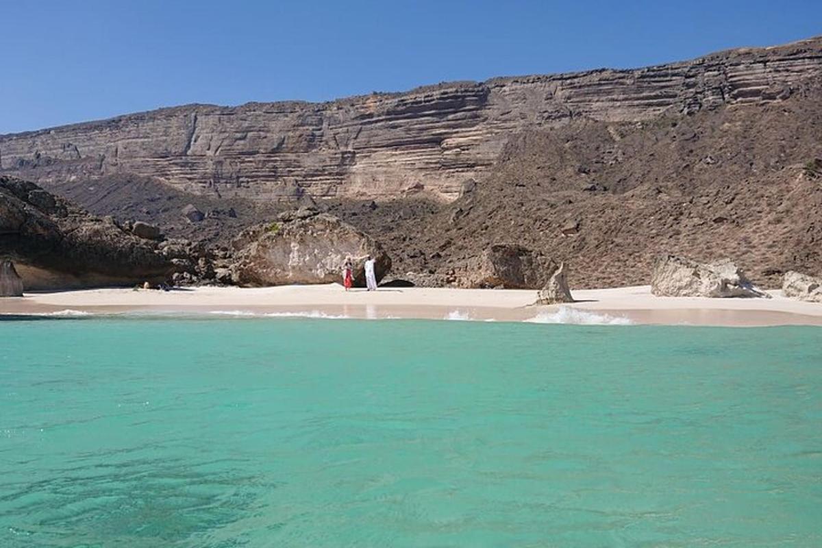 a beach with the ocean and a mountain