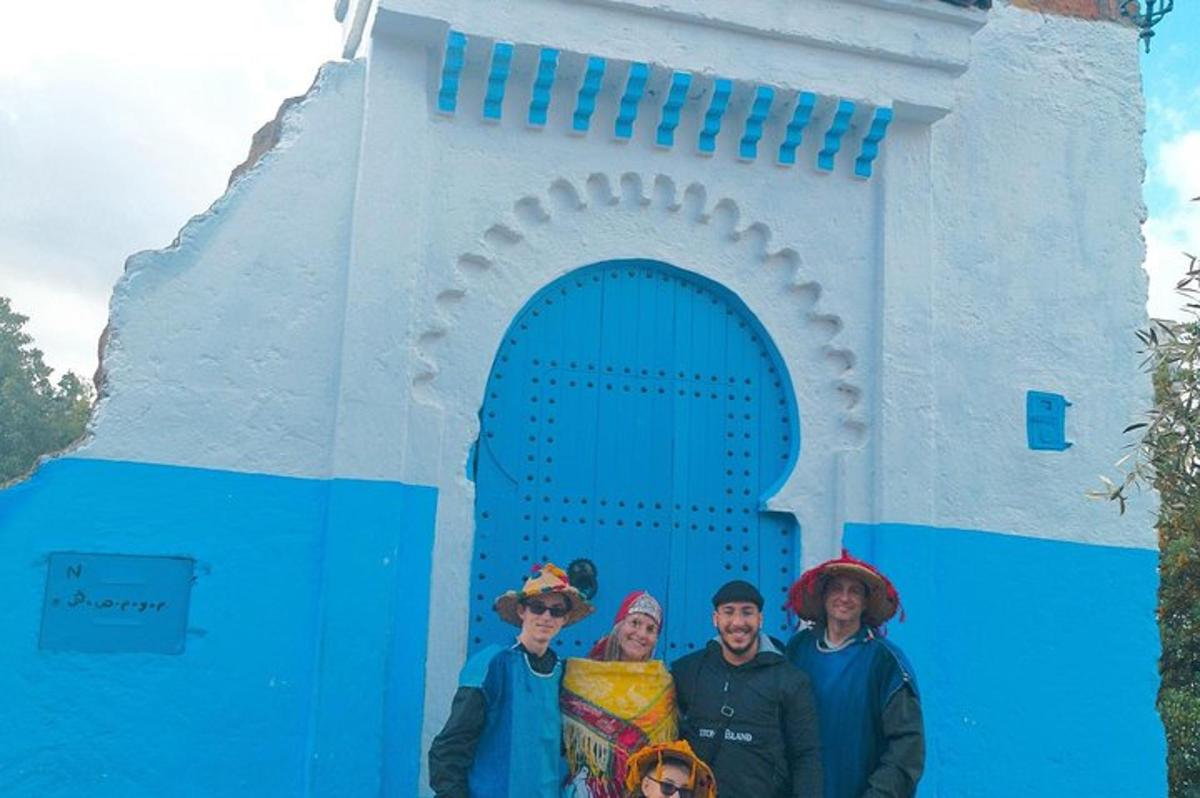 un grup de persones dretes davant d'un edifici blau