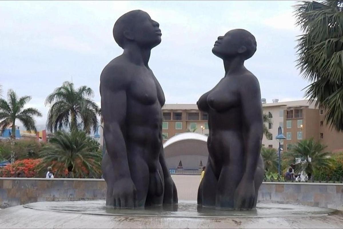 two statues of two people standing in a fountain