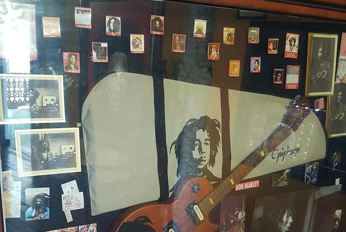 a room with a guitar on a wall with pictures
