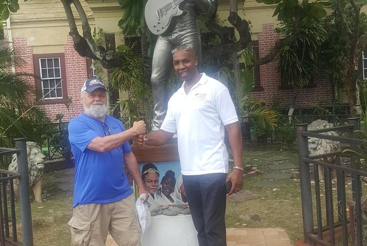two men are standing in front of a statue