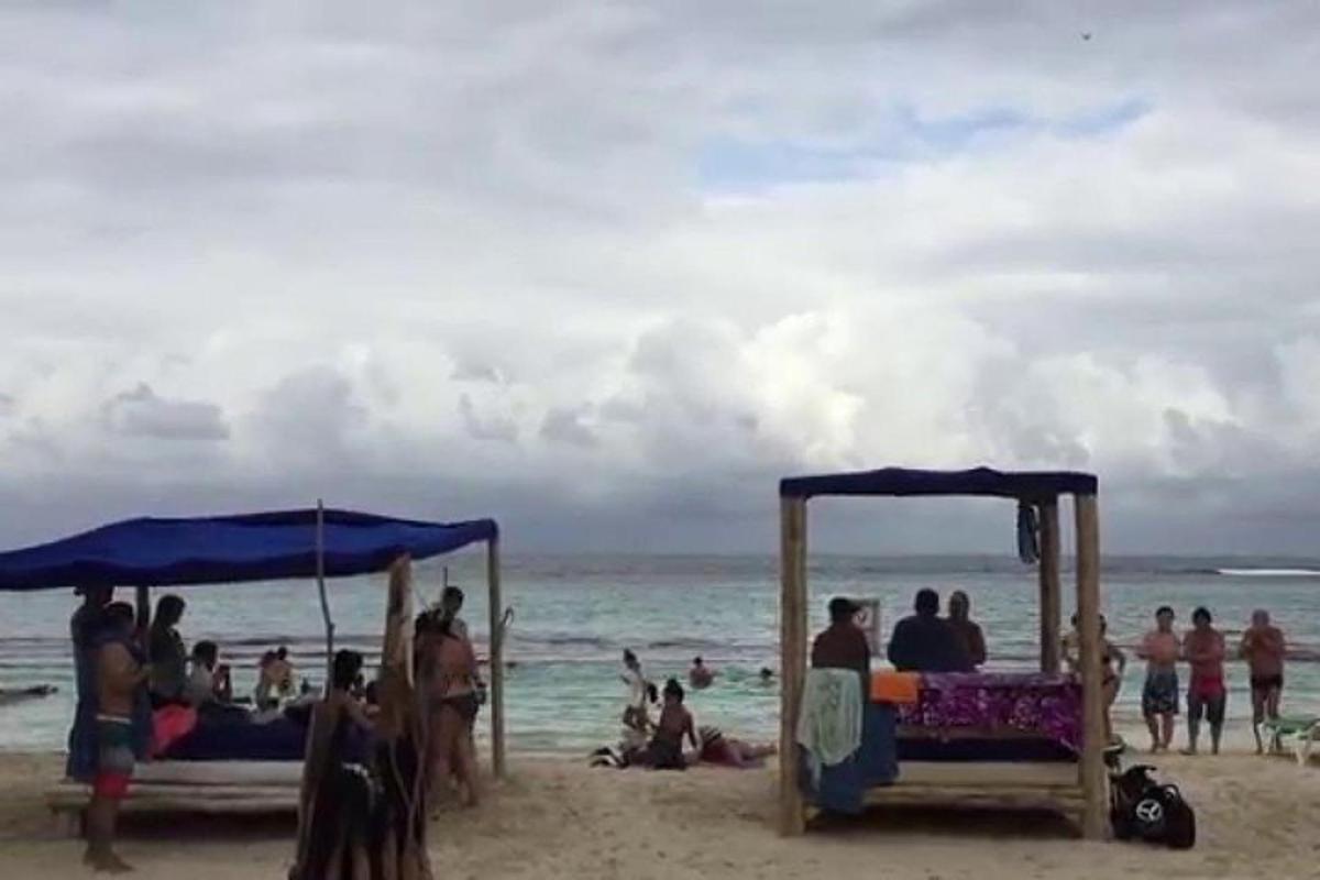 een groep mensen die op een strand zitten