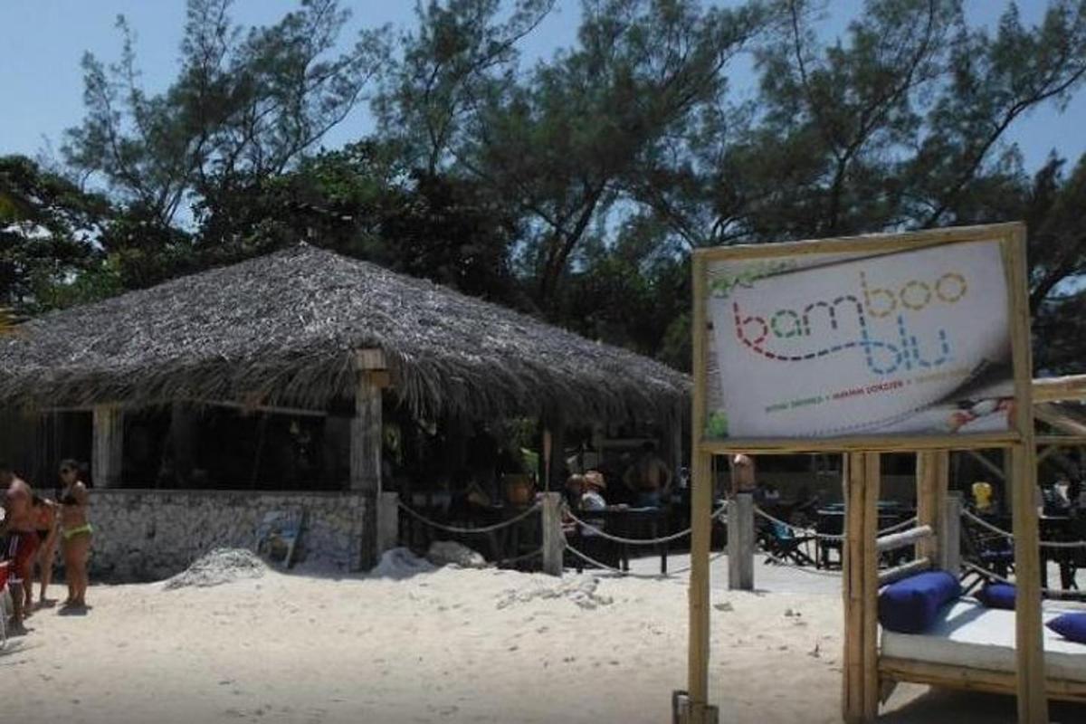 un rètol a la platja amb un menjar de bar