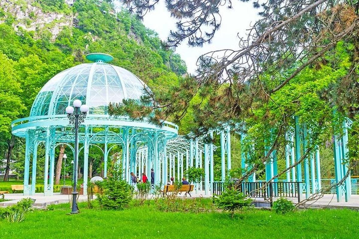 блакитна альтанка в парку із зеленою травою