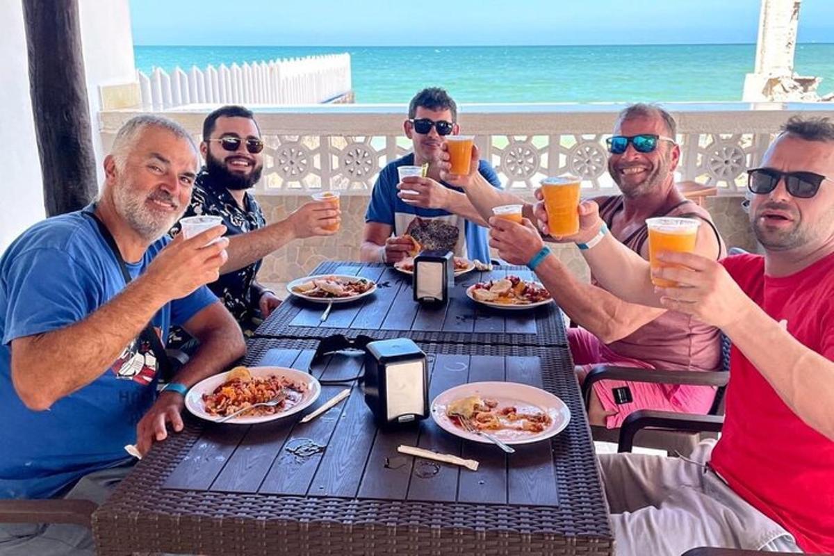 a group of men sitting around a table drinking beer