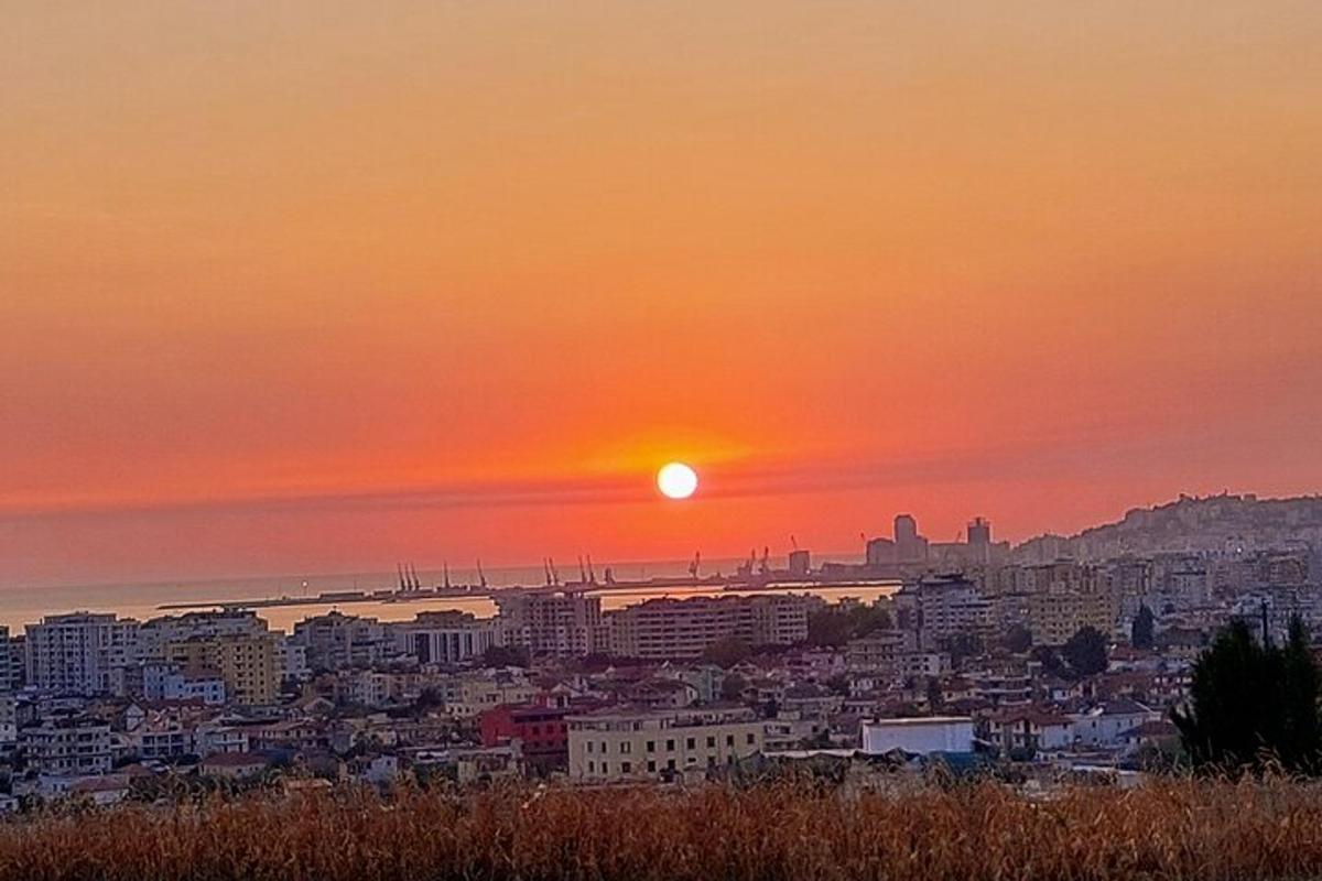 ένας ορίζοντας πόλης με τον ήλιο να δύει στον ουρανό