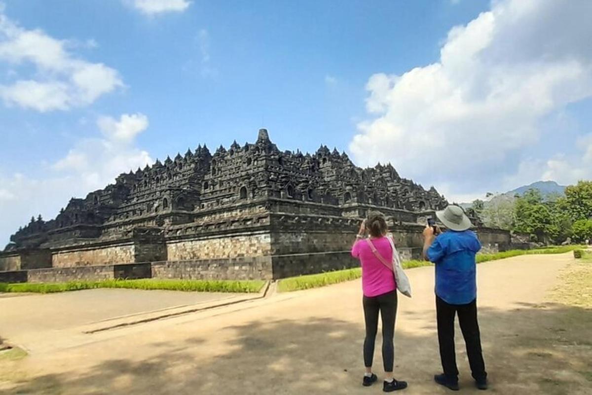 un uomo e una donna che scattano una foto di un tempio