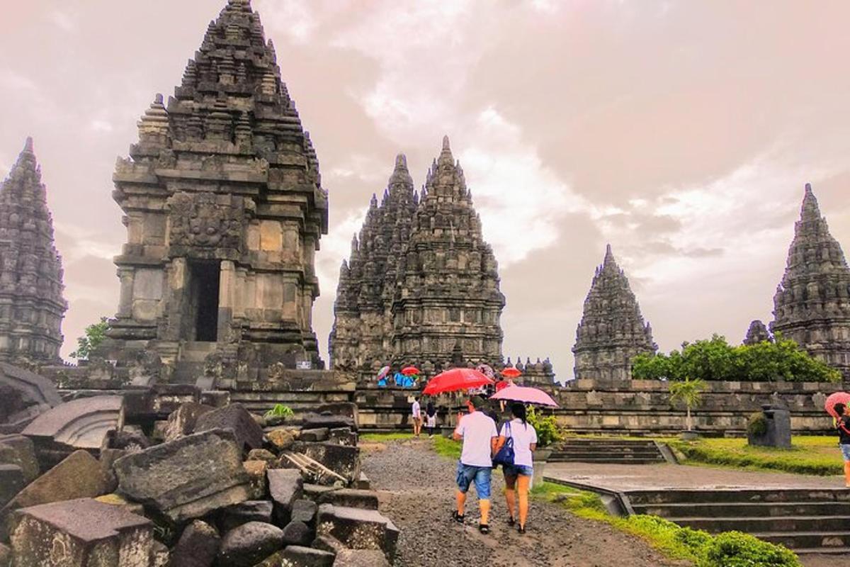 due persone con gli ombrelli che camminano davanti a un tempio