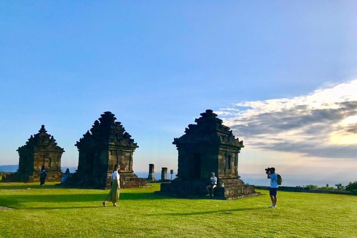 un gruppo di persone in piedi in un campo con templi