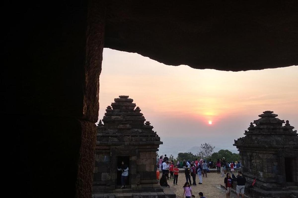 un gruppo di persone che camminano intorno a un tempio al tramonto