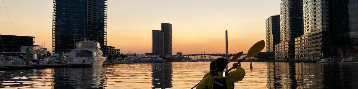 a person on a boat in a river with buildings
