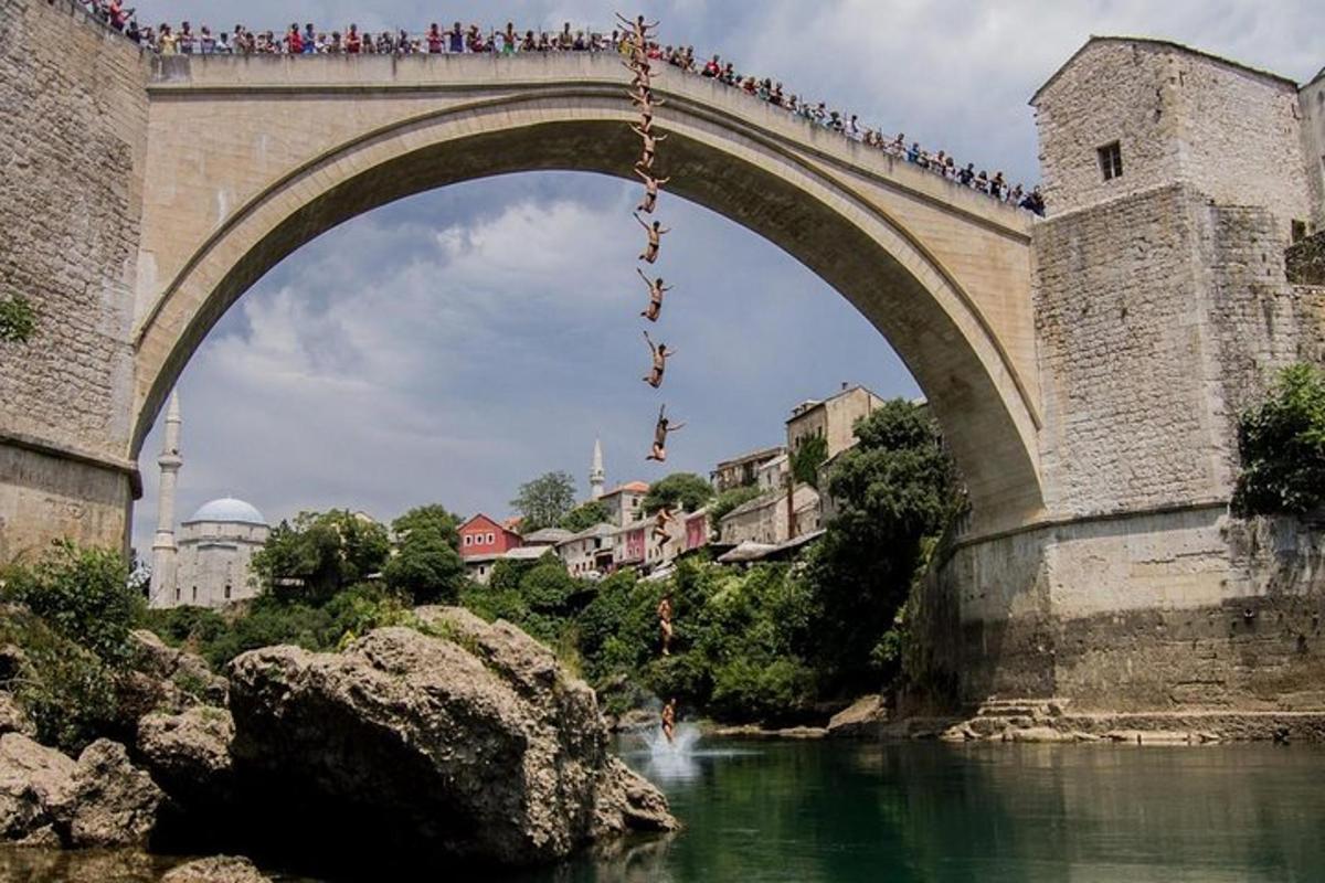 μια γέφυρα πάνω από ένα ποτάμι με ένα σωρό ανθρώπους πάνω της