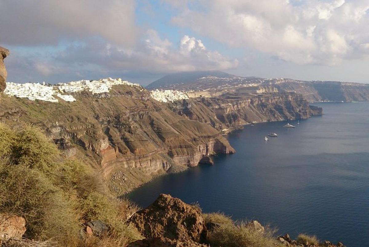 Un gran cuerpo de agua con barcos en una montaña.