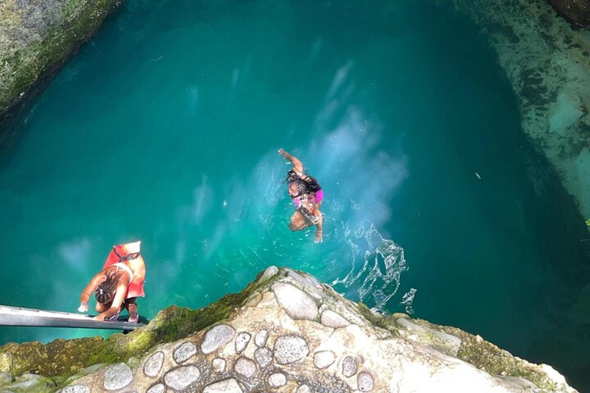 due persone che si tuffano nell'acqua di una grotta