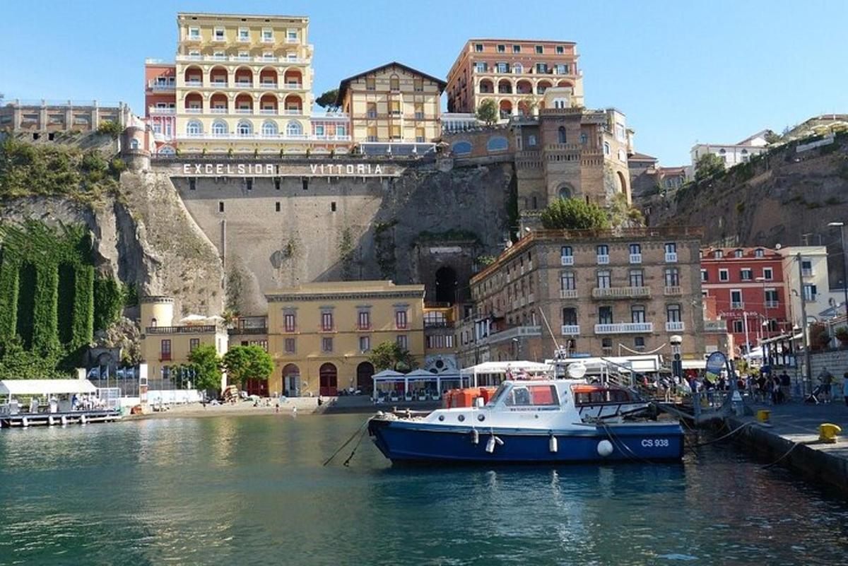 a blue and white boat in the water with buildings