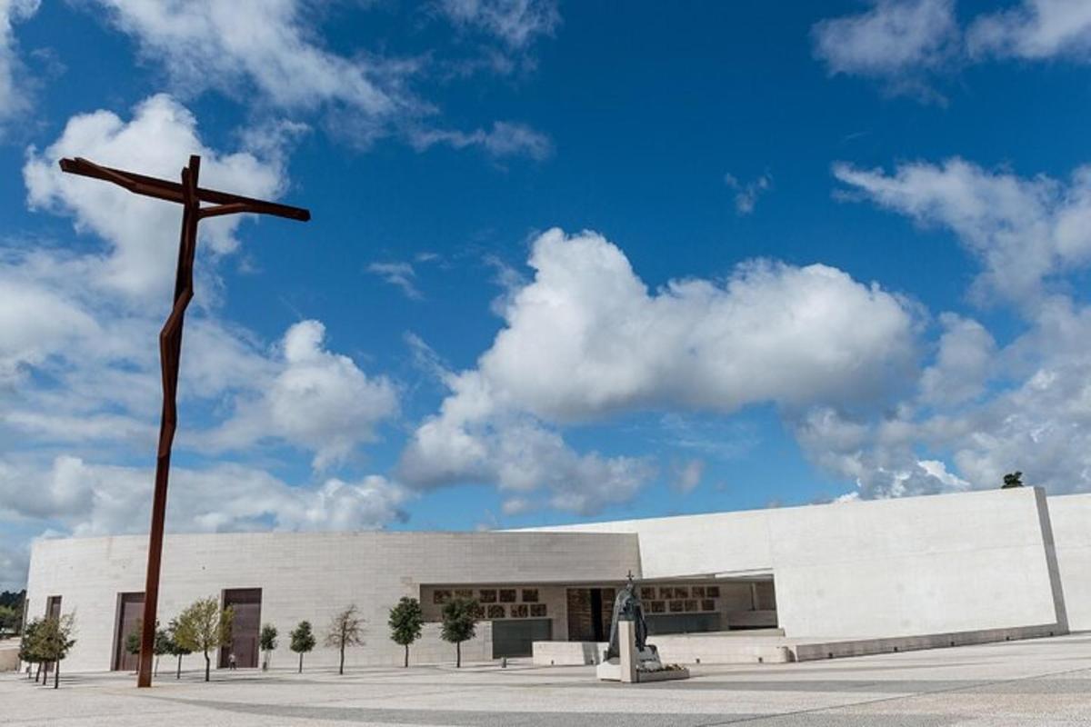 μια εκκλησία με έναν σταυρό μπροστά από ένα κτίριο