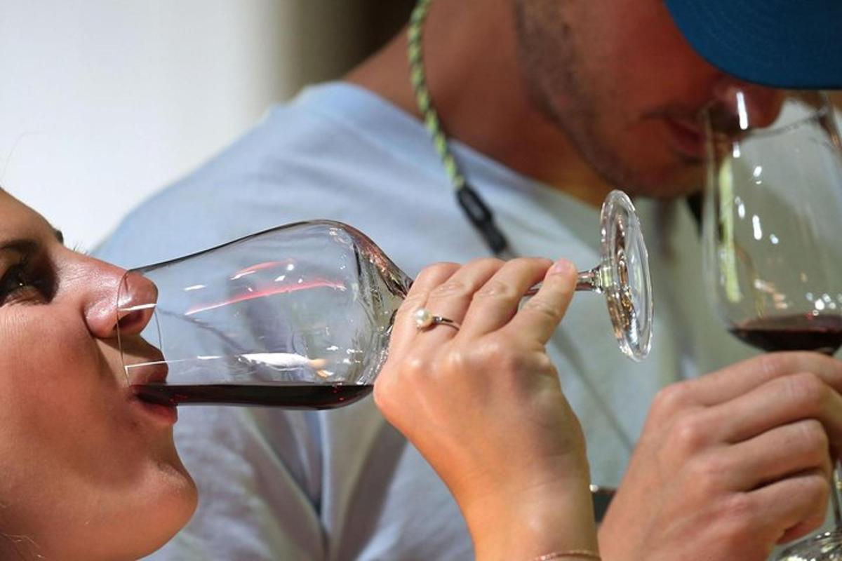 Una mujer bebiendo una copa de vino tinto con un hombre