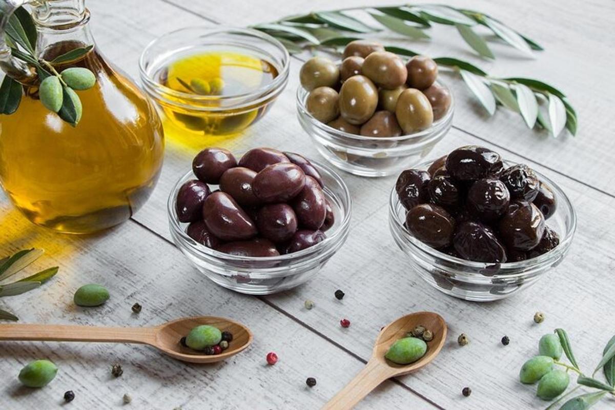 un tavolo sormontato da ciotole di olive e cucchiai di legno