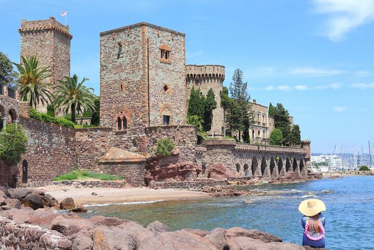 o fetiță stând pe o stâncă în fața unui castel