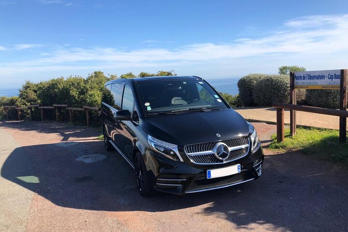 Ένα μαύρο βαν Mercedes Benz παρκαρισμένο δίπλα σε μια πινακίδα