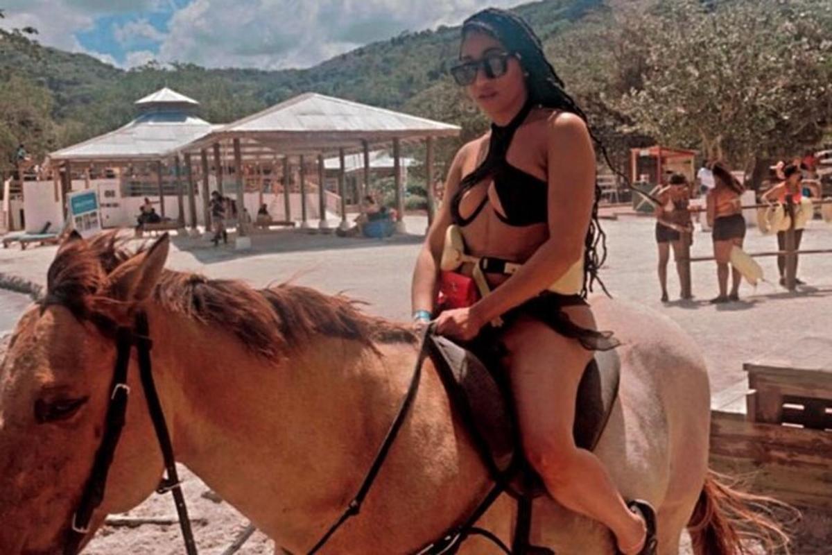 sieviete bikini jāj ar zirgu pludmalē